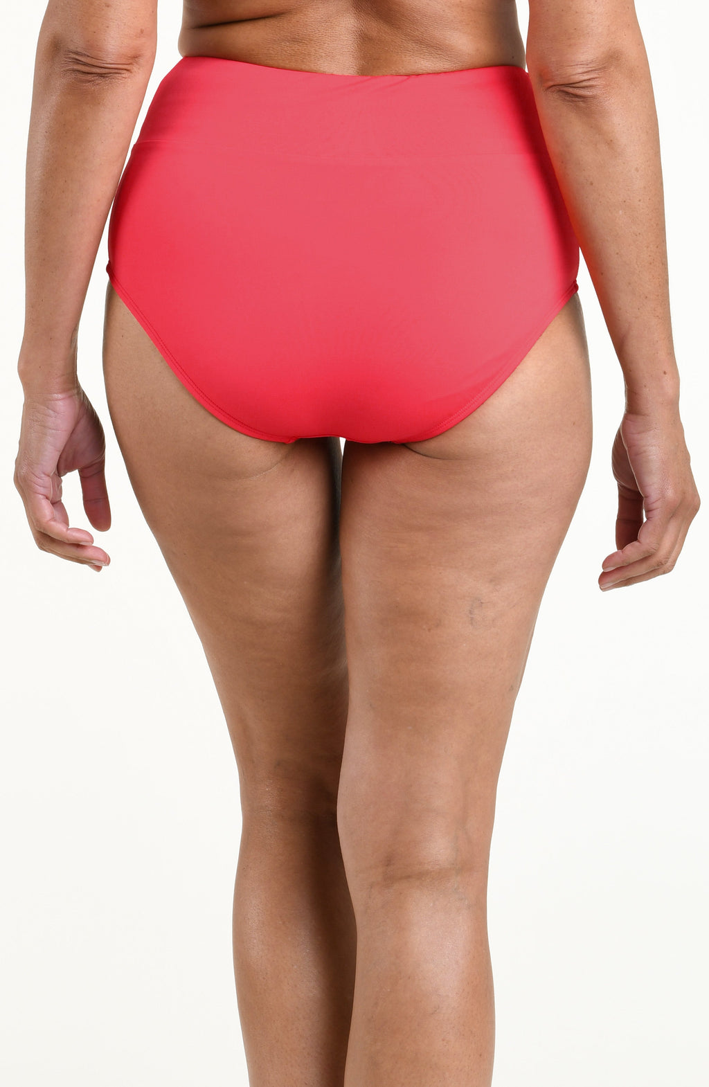 Woman wearing a solid bright orange mid waist bottom against a white background. 