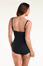 Woman wearing a solid black bandeau one piece swimsuit against a white background. 