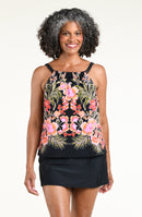 Woman wearing a black multicolored tankini top and solid black swim skirt against a white background. 