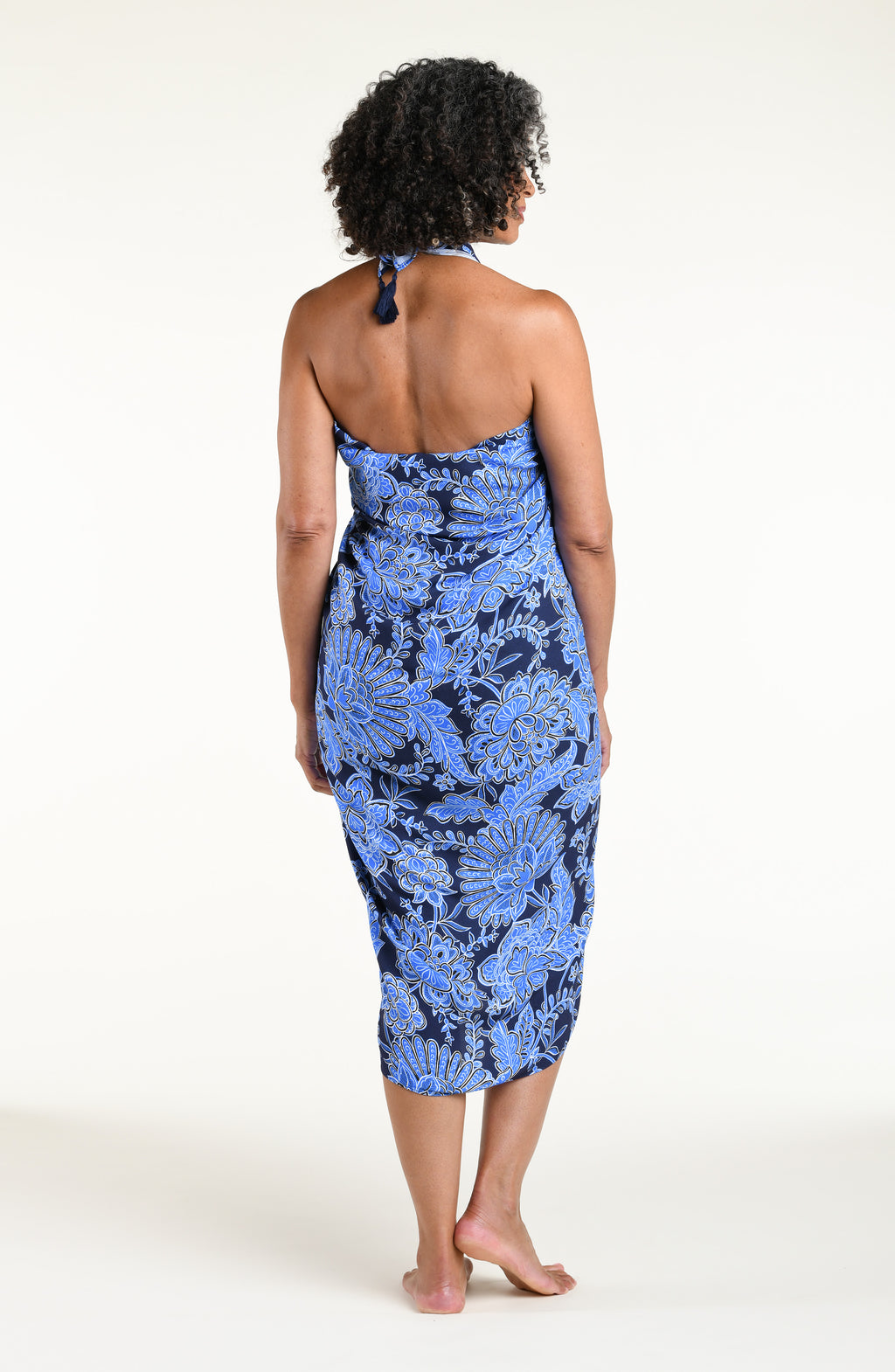 Woman wearing an indigo blue multicolored sarong against a white background. 