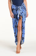Woman wearing an indigo blue multicolored sarong against a white background. 