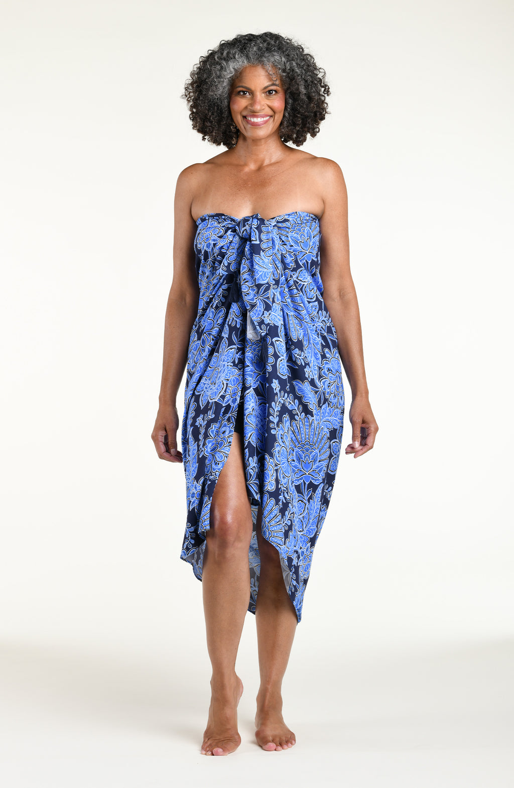 Woman wearing an indigo blue multicolored sarong against a white background. 