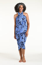 Woman wearing an indigo blue multicolored sarong against a white background. 