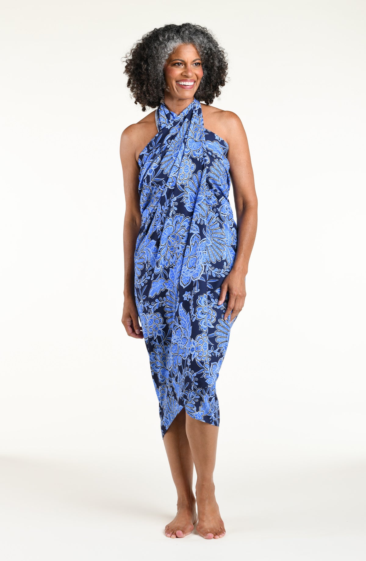 Woman wearing an indigo blue multicolored sarong against a white background. 