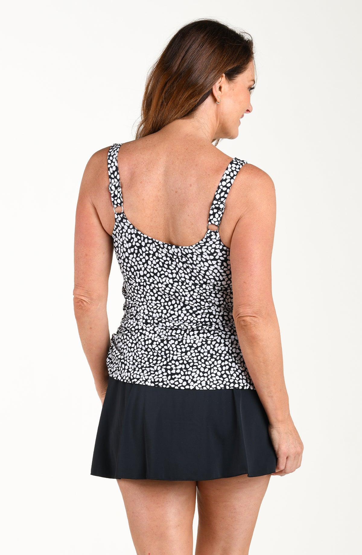 Woman wearing a black and white patterned swim dress on a white background