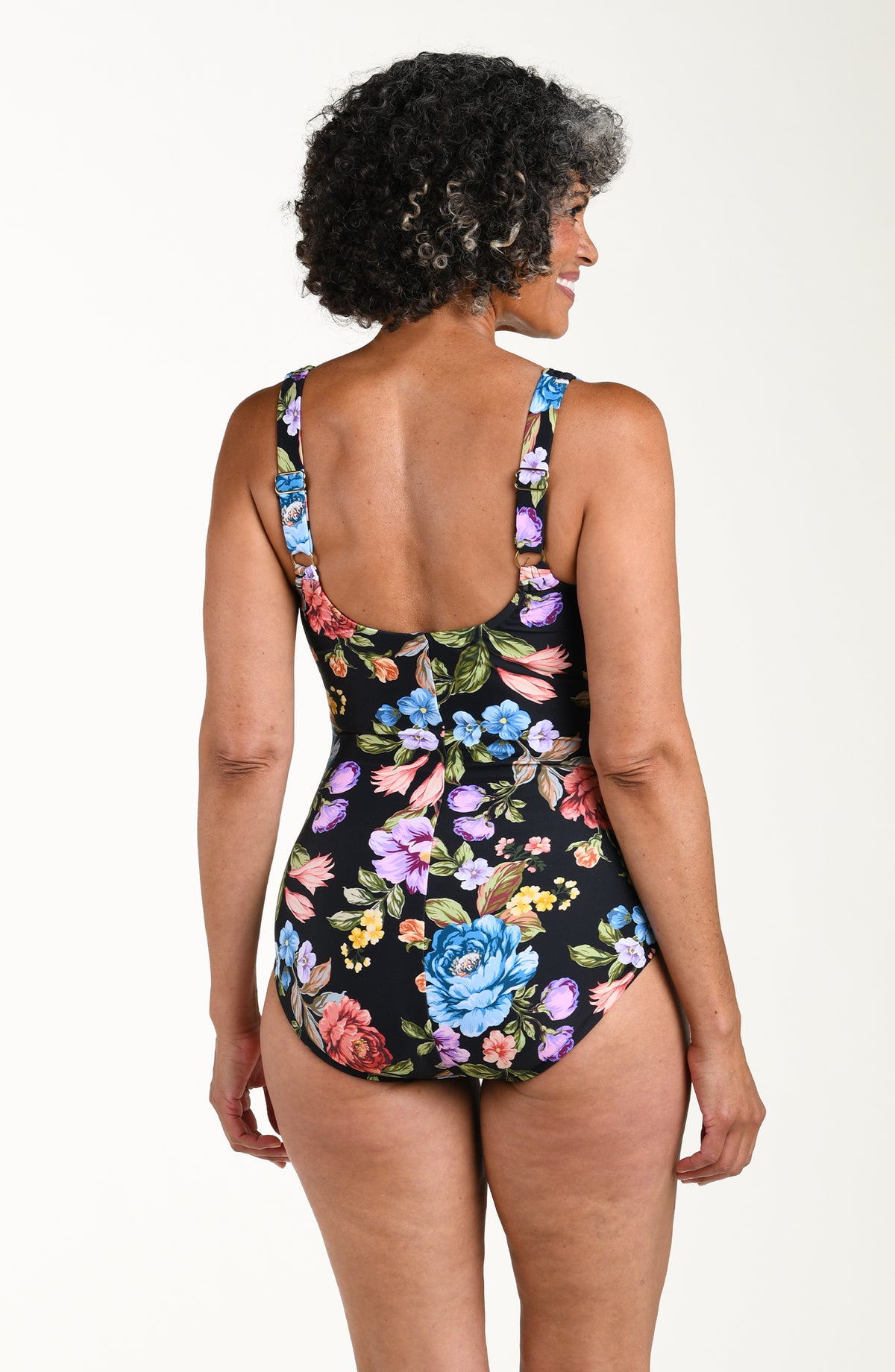 Woman wearing a floral one-piece swimsuit on a white background