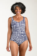 Front image of model wearing a multicolored navy blue paisley printed one-piece swimsuit featuring wide straps, a subtle V-neckline, tummy control, and a smooth, fitted silhouette. 