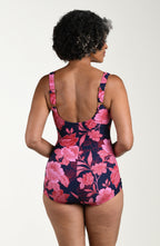 Back image of model wearing a multicolored (pink) floral printed one-piece swimsuit with wide straps, a scoop back, ruched body, and full rear coverage.