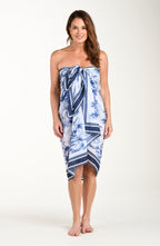 Full body front image of model wearing a multicolored white and blue tropical pareo which is tied at the bustline. 