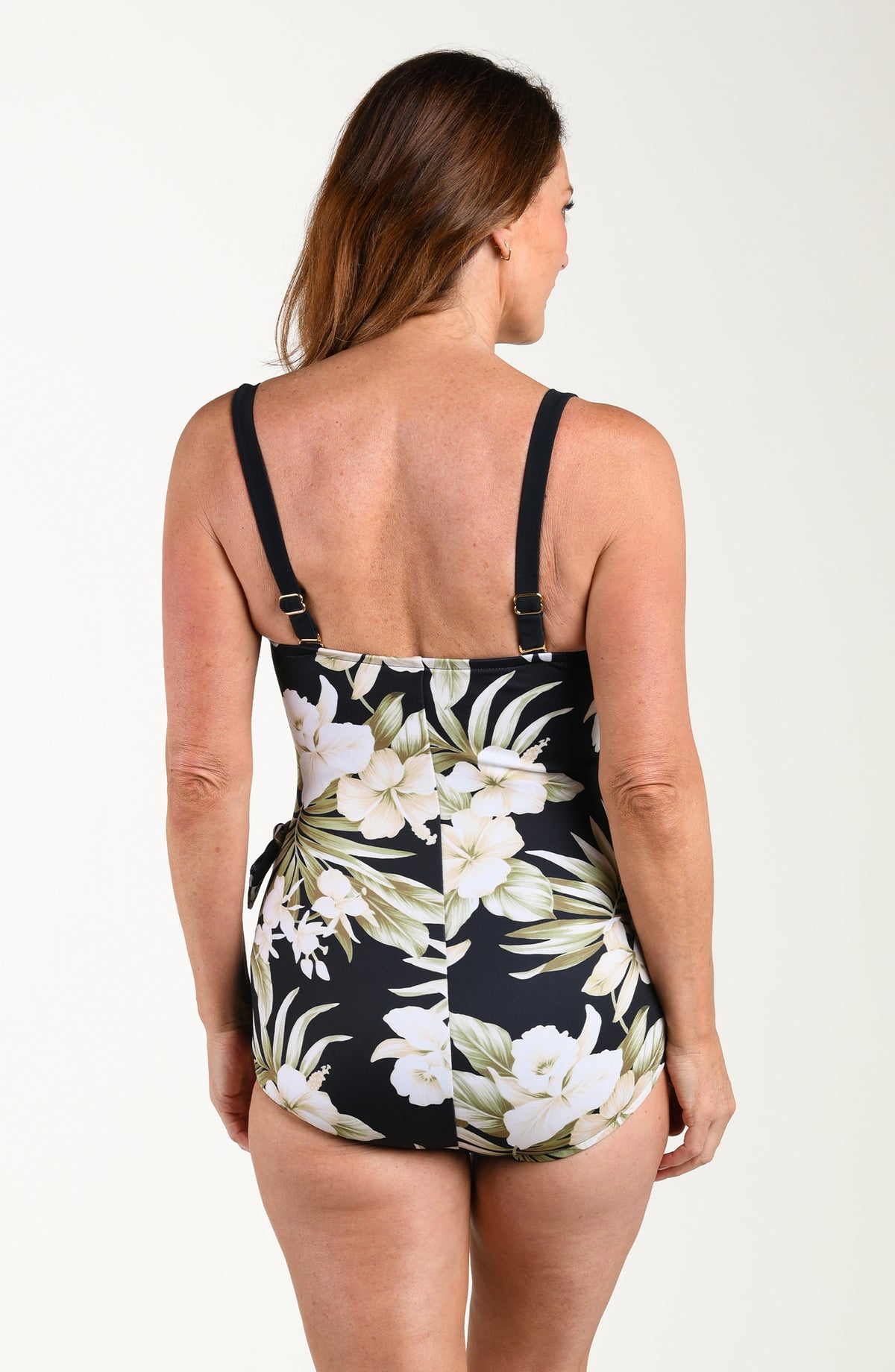 Woman wearing a black floral swimsuit on a white background