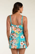 Woman wearing a floral tankini top and matching swim skirt with a white background
