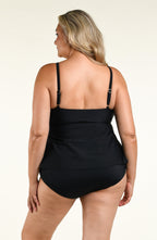 Woman wearing a solid black double tiered tankini top and matching bottom against a white background. 