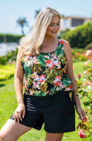 Model wearing a bandeau blouson tankini top with a tropical print and swim shorts.