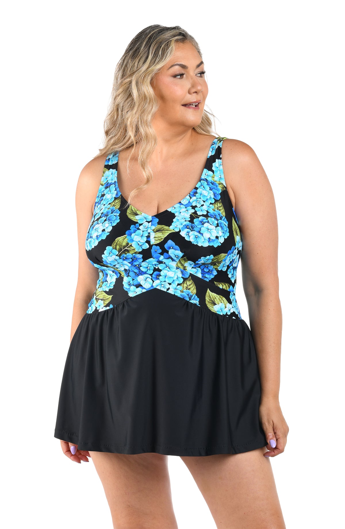 Woman wearing a black swim dress with a blue floral pattern on a white background