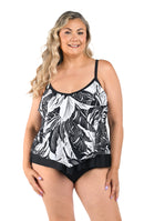Woman wearing a black and white leaf-patterned tankini and black bottoms on a white background
