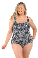 Woman wearing a black and white leaf-patterned swimsuit on a white background