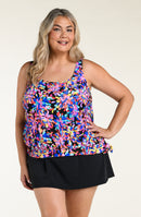 Woman wearing a colorful floral tankini top and black swim skirt against a white background.