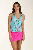 Woman wearing a tropical tankini top and pink swim skirt on a white background