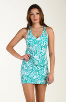 Woman wearing a teal and white patterned tankini top and matching swim bottom on a beige background