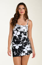 Front image of model wearing a multicolored black and white floral printed swim skort featuring a high waist, built in short, and pocket. This is paired with a matching tankini top.