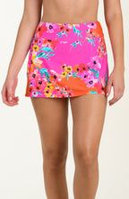 Front image of model wearing a multicolored floral printed swim skort featuring a high waist, built in short, and pocket. 