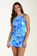 Woman wearing a blue floral tankini and swim skirt on a white background