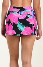 Back image of model wearing a multicolored tropical printed swim skort featuring twist front detail and full coverage. 