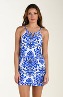 Woman wearing a blue and white patterned dress on a beige background